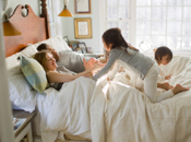 kids playing with parents in bed home