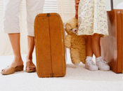 Children with suitcases and teddy bear